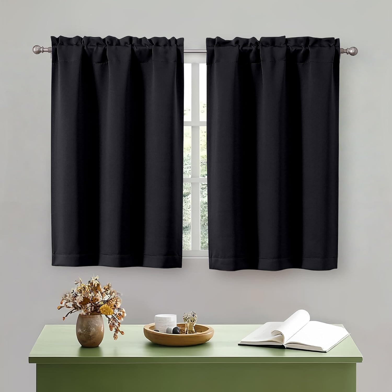 Two short black curtain panels above a console