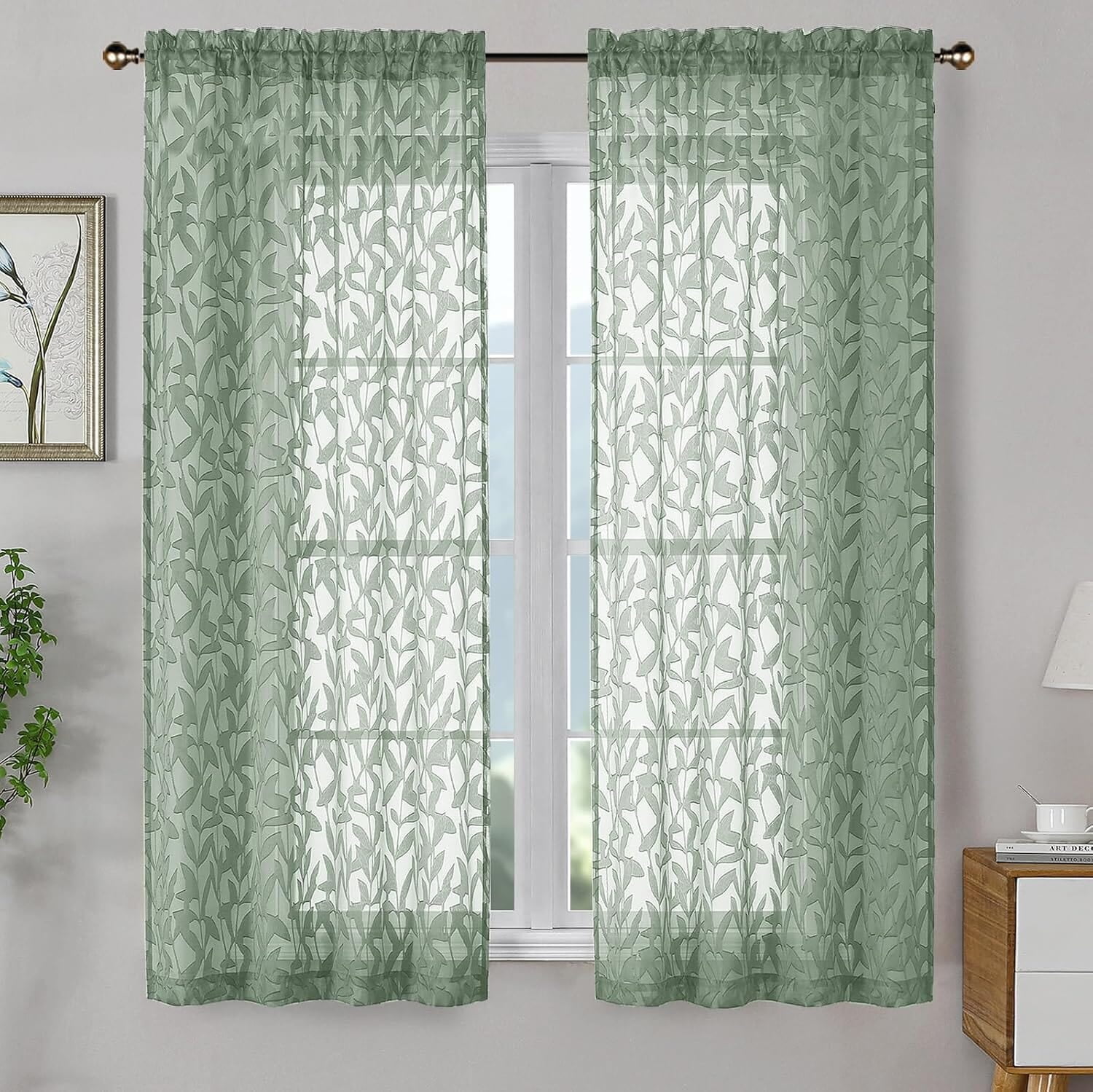 Two sage-green sheer curtain panels with a leaf pattern