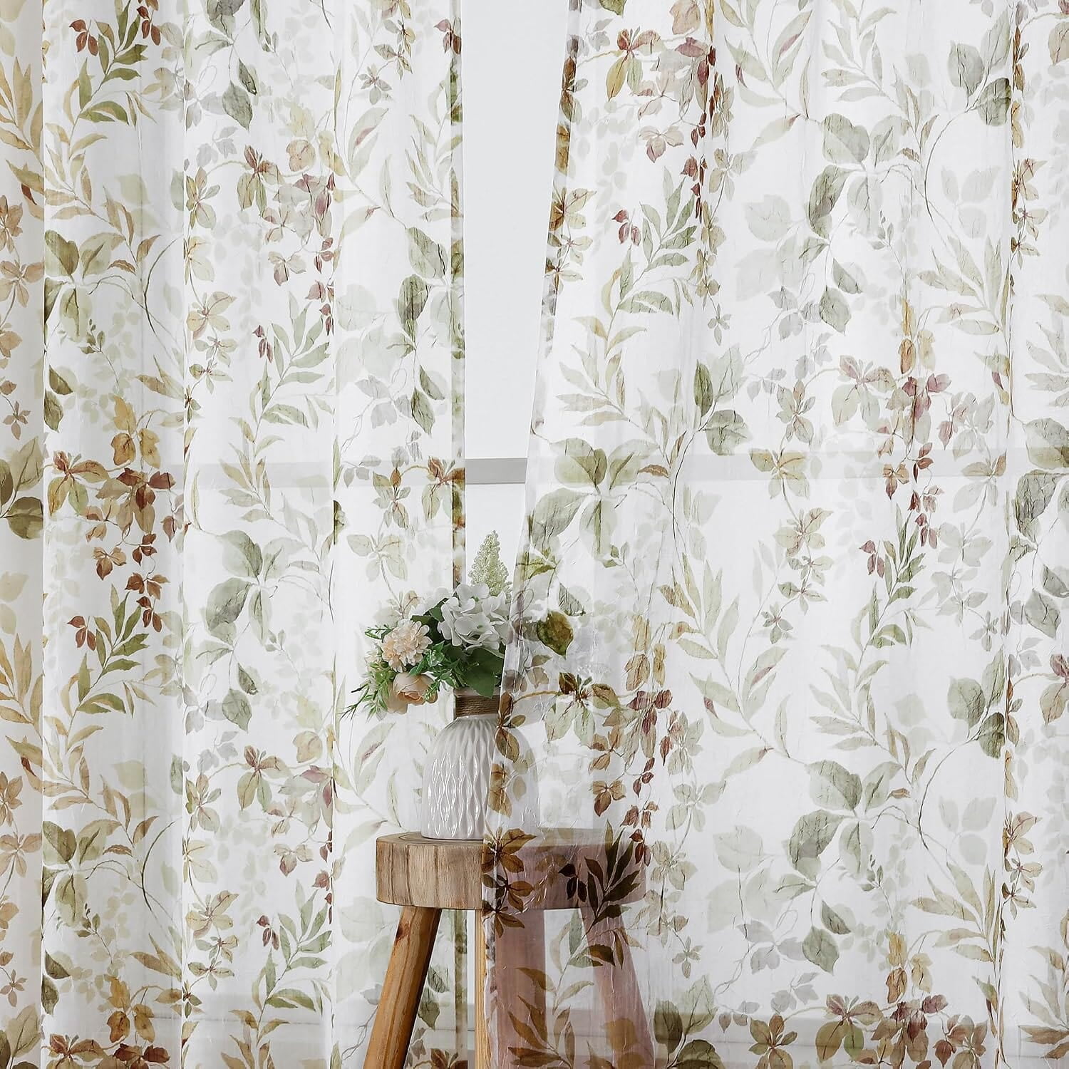 A close-up of translucent crushed curtains with brown, taupe and green leafy stems; full panel dimensions are not shown